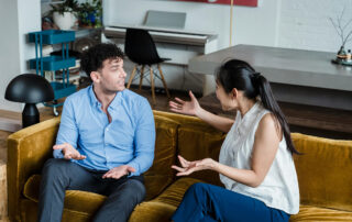 Couple fighting on the couch being critical