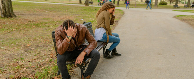 Couple sitting on a bench having a fight