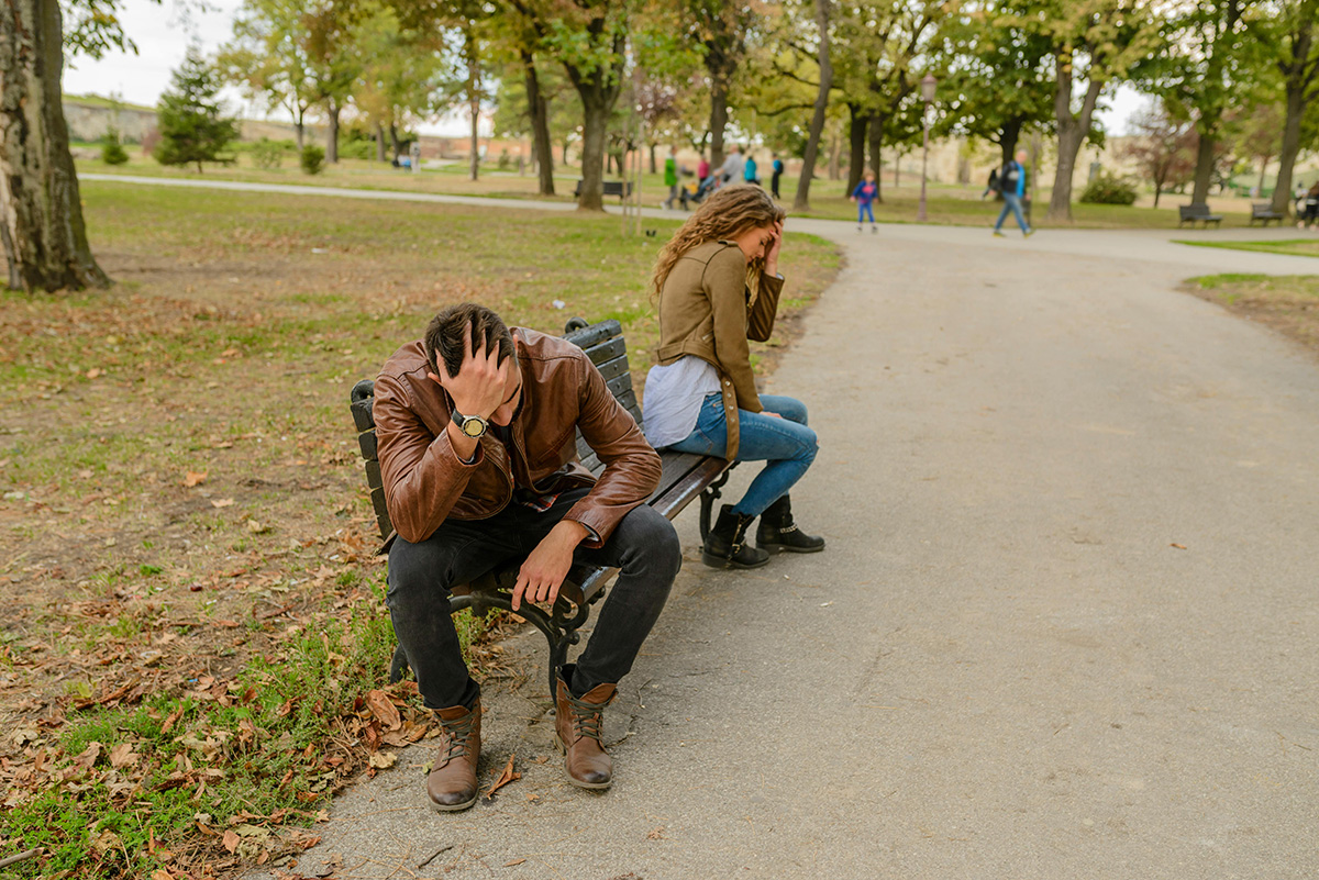 Couple sitting on a bench having a fight